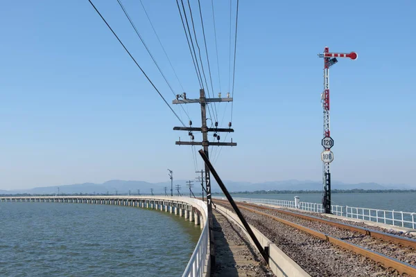 The traffic signal pole in the not allowed position of the railway signaling system on the curved concrete bridge along the reservoir, front view with the copy space.