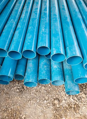 Yeni PVC boru yığını, kırsal köylerdeki su tedarik sisteminin hazırlanması için inşaat sahasının yanında..
