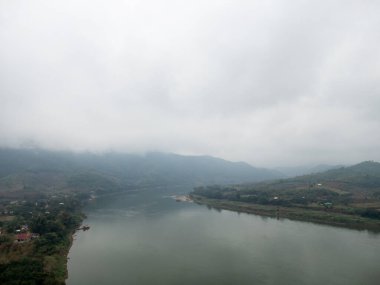 Tayland 'ın kuzeydoğu kesimindeki yağmurdan sonra, büyük nehrin yanındaki dağ sıraları bulutlarla kaplıdır..