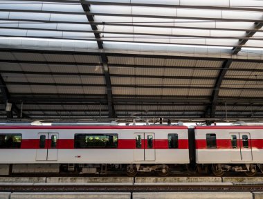 Elektrikli tren, işten sonra bir banliyö istasyonundan yolcuları almak için durur, fotokopi alanının olduğu ön manzara, fotokopi alanının olduğu ön manzara..