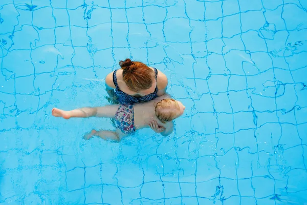 행복 한 가족. 엄마는 2-3 살 짜리 딸에게 수영장에서 수영하는 법을 가르친다. 위에서 본 풍경. — 스톡 사진