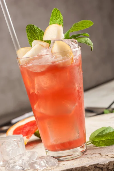 Red drink with grapefruit, pears and ice — Stock Photo, Image