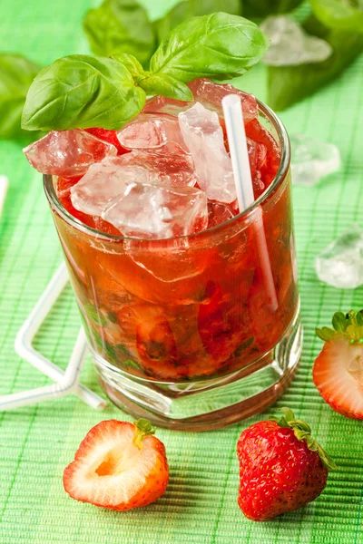 Red drink on a green background and ice — Stock Photo, Image