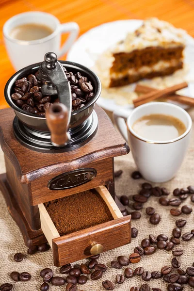 Coffee grinder, cup of coffee and cake — Stock Photo, Image