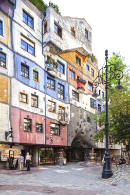 Vienna, Austria - August 30, 2013. Tourists walk around the Hundertwasserhaus Was made by Fredensreich Hundertwasser Und Josef Krawina. Colored building.