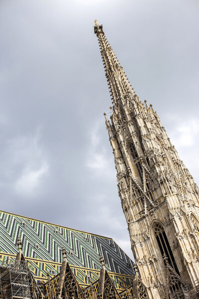 Vienna, Austria Fragment of St. Stephen s Cathedral in Vienna with main 136 meter high tower. Cloudy sky above the tower.