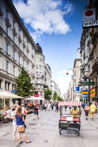 Vienna, Austria - September 01, 2013: Tourists form all over the World walks among one of the main streets, Kartner Strasse form Wiener City Opera to Stephansplatz. — Stock Photo, Image