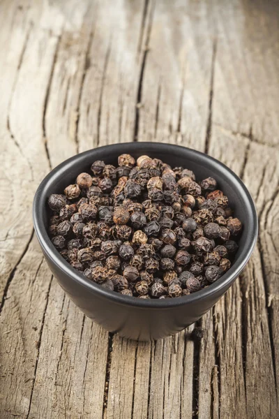 Black pepper spice in black bowl — Stock Photo, Image