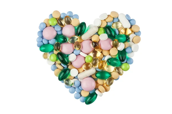 Forma do coração feito de pílulas coloridas e cápsulas, isolado em branco — Fotografia de Stock