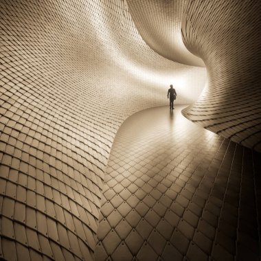 Concept or conceptual dark tunnel with a bright light at the end or exit.  3d illustration as metaphor to success, faith, future or hope, a black silhouette of walking man to new opportunity freedom