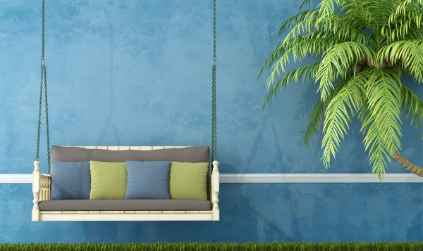 Vintage wooden swing against blue wall — Stock Photo, Image