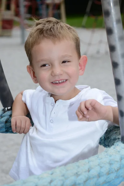 Ragazzo dall'aspetto divertente al parco giochi — Foto Stock