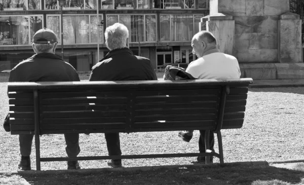 Three persons sitting on the bench — Stock Photo, Image