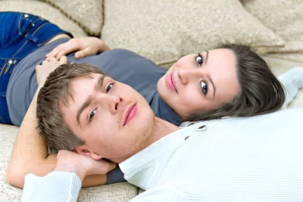 Junger Kerl und ein Mädchen liegen auf der Couch — Stockfoto