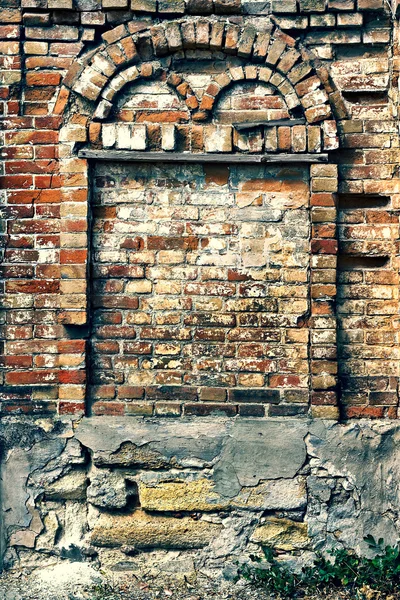 Crumbling brick wall with arch — Stock Photo, Image