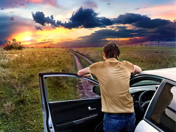 adam arabanın yakınında duran ve batımını