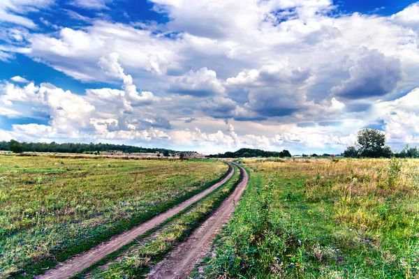Estrada rural no meio do campo — Fotografia de Stock