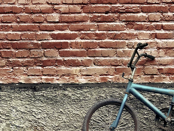 Old rusty vintage bicycle leaning against a brick wall — Stock Photo, Image