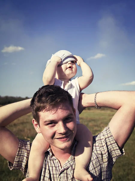 Father holds a small child on his shoulders — Stock Photo, Image