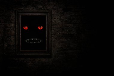 Eski tuğla duvarda, canavar gözlü ve dişli klasik çerçeve.