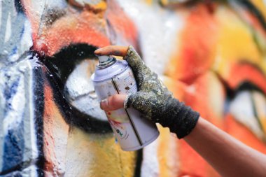Graffiti sanatçısı bir duvarı sprey boyayla boyuyor, grafiti sprey boyayla boyama sanatlarından biri..