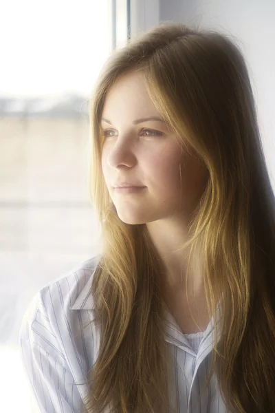 Portrait of a girl at the window — Stock Photo, Image