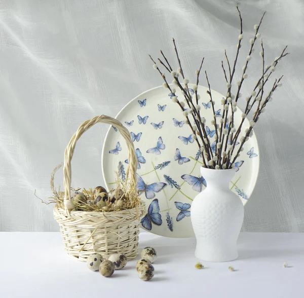 Quail eggs in a basket and willow branches — Stock Photo, Image