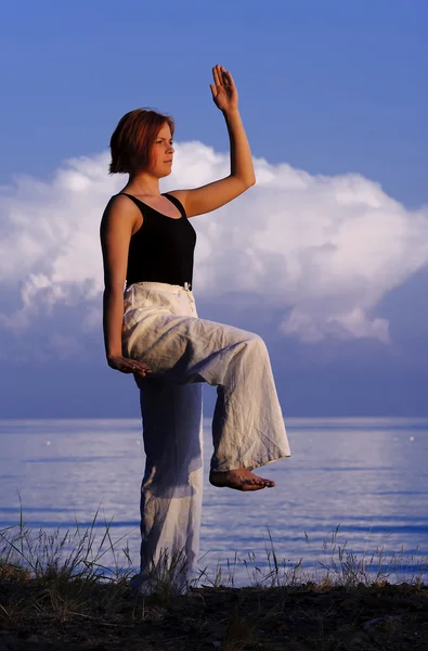 Mladá žena, která dělá jógu mimo — Stock fotografie