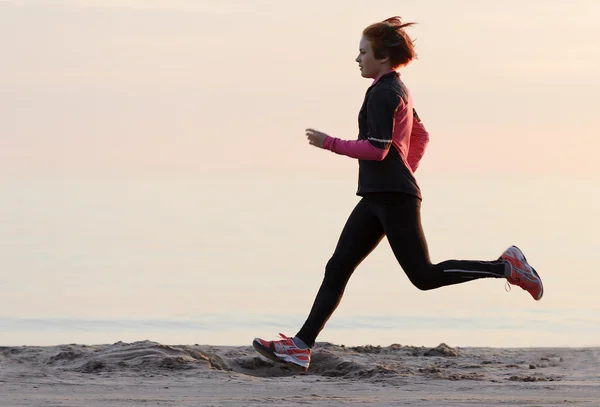 Young woman running along the waterfront — Stock Photo, Image