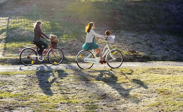 Dvě dívky, jízda na kole v parku — Stock fotografie