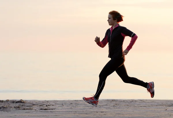 Young woman running along the waterfront — Stock Photo, Image