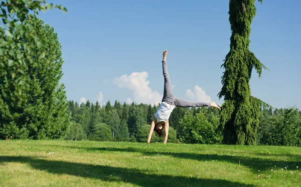 Junge Frau macht Wagenrad draußen — Stockfoto