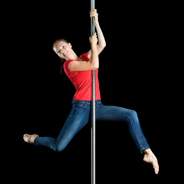 Jovem sexy mulher exercício pole dance contra um fundo cinza — Fotografia de Stock