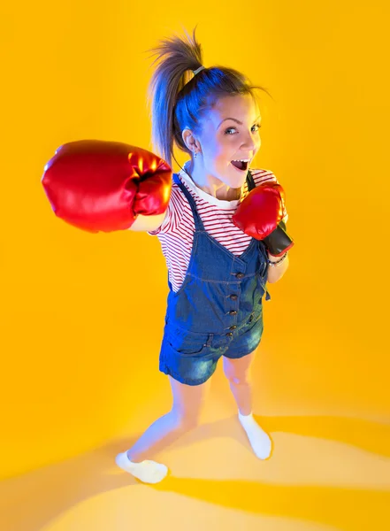 Mujer divertida fitness con guantes de boxeo, aislado en amarillo — Foto de Stock