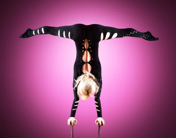 Circus actor standing on the hand on a red background — Stock Photo, Image