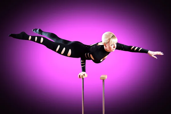 Circus actor standing on the hand on a purple background — Stock Photo, Image