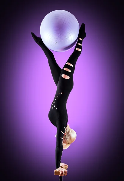 Circus actor standing on the hand on a purple background — Stock Photo, Image