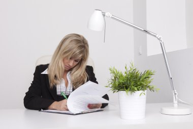 Resepsiyon ve okuma kontratına oturan bir takım elbise içinde genç bir kadın