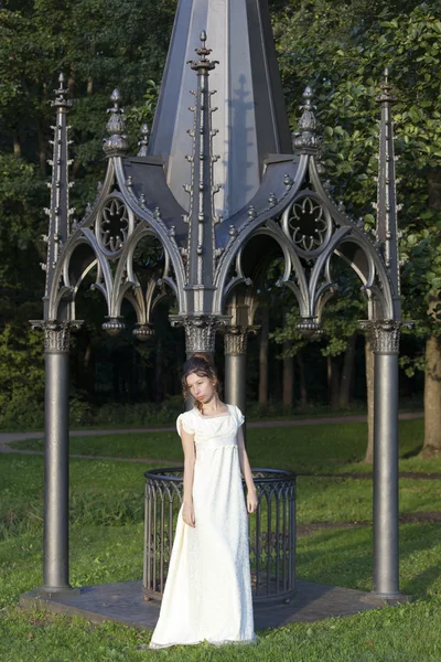 Молода дівчина в довгій білій сукні — стокове фото
