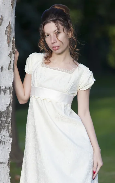 Молодая девушка в длинном белом платье — стоковое фото
