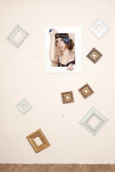 Retrato de una chica en un marco colgado en la pared —  Fotos de Stock