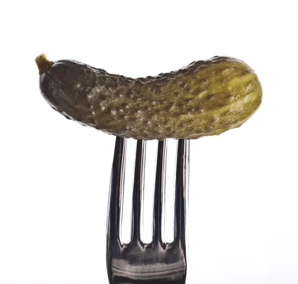 Pepino en escabeche, empalado en un tenedor, sobre fondo blanco — Foto de Stock