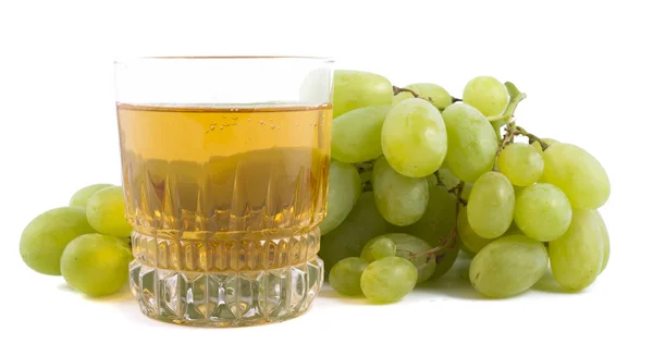 Massa gröna druvor och ett glas druvsaft, isolerad på vit bakgrund — Stockfoto