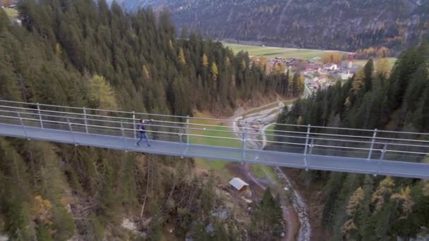Mädchen Überquert Fußgängerbrücke Über Schlucht Der Schweiz — Stockvideo