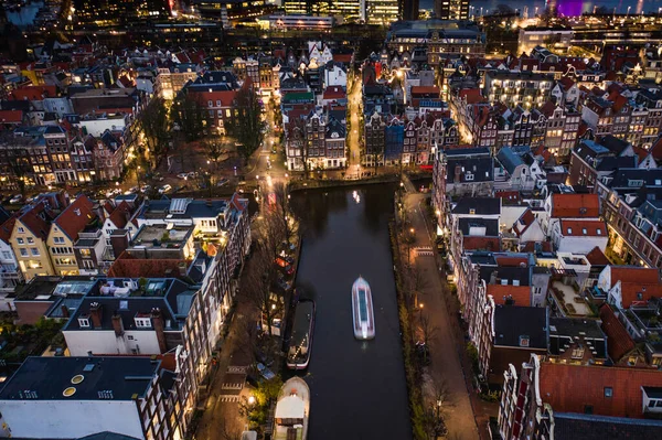 Amsterdam City Canals at Night with a Tour Boat Aerial View