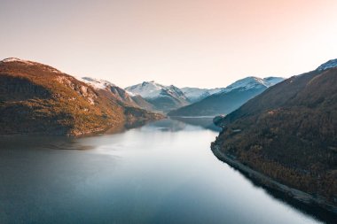 Gündoğumu Norveç 'in fiyortlarla, ormanlarla ve dağlarla çevrili manzarasına bakıyor