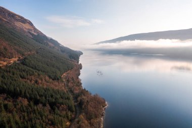 Sabahları dağlarla çevrili bir göldeki kanocular