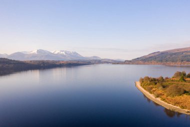 Gün batımı İskoçya 'da bir gölün üzerinde görünüyor