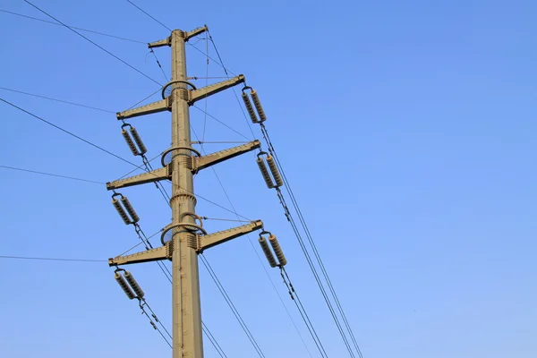 Línea de transmisión de alta tensión bajo el cielo azul — Foto de Stock