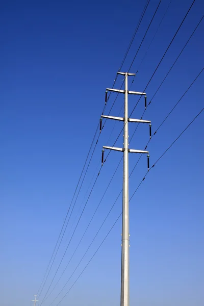 Postes eléctricos bajo el fondo azul del cielo — Foto de Stock